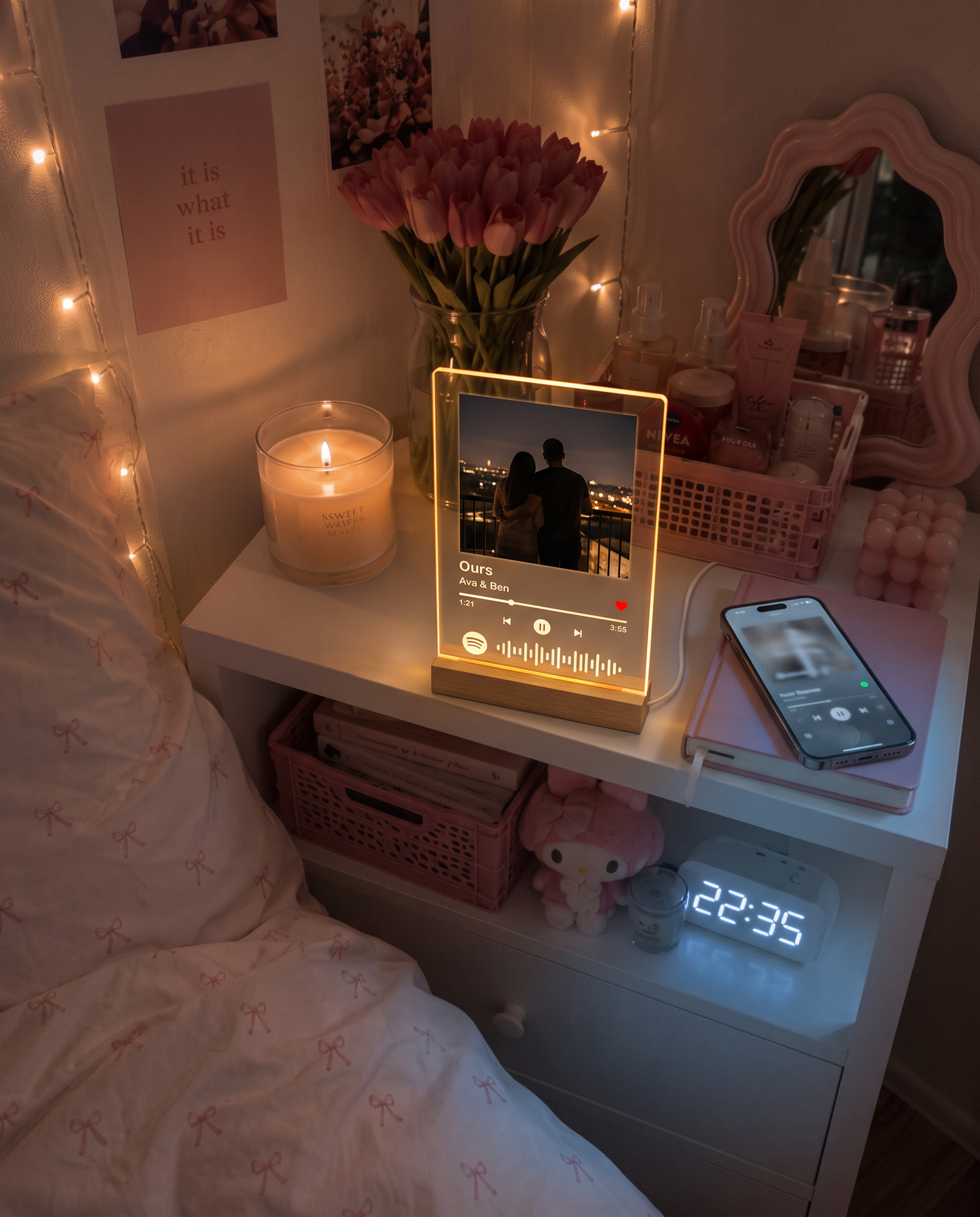 Spotilight leuchtet auf dem Nachttisch, daneben ein Smartphone, das den Song abspielt
