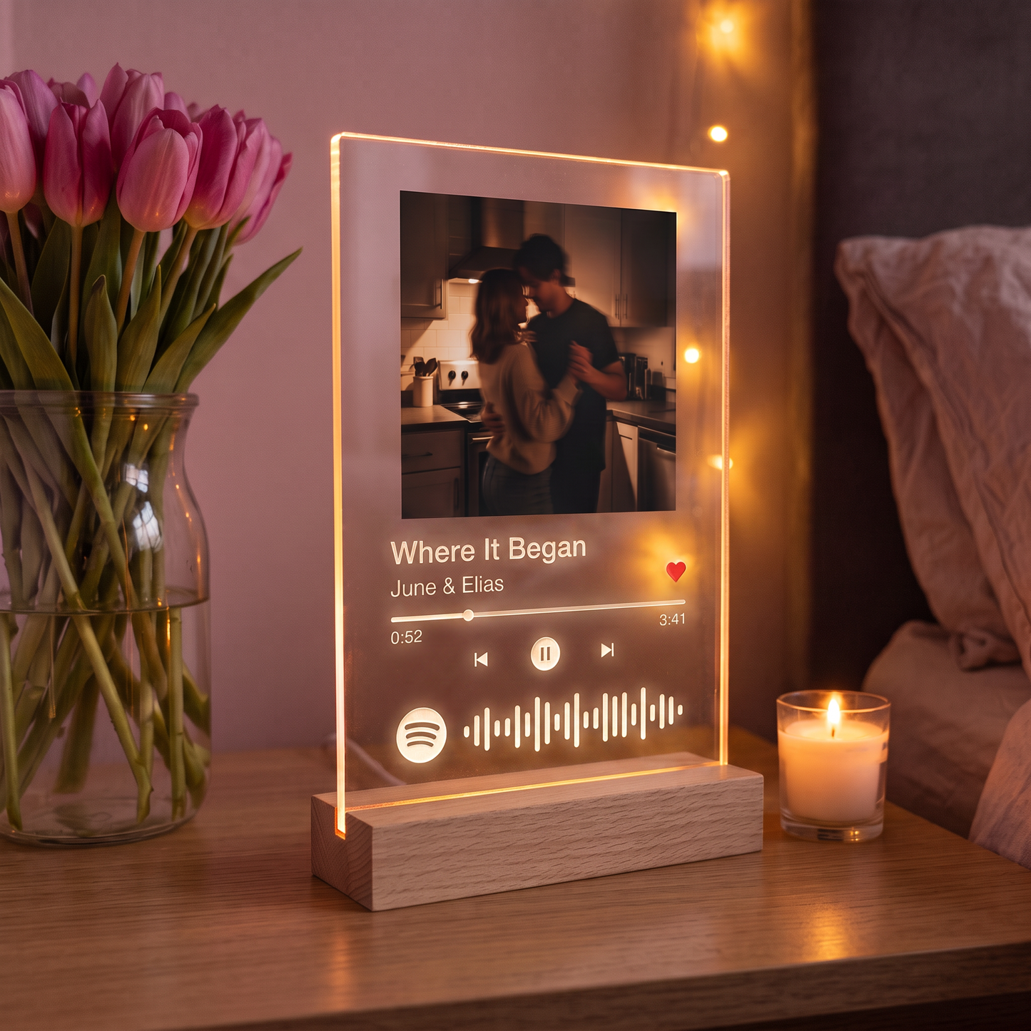 Personalised Spotilight acrylic panel showing a photo, song title and scannable code, glowing on a bedside table